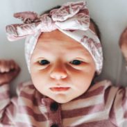 A baby in striped pajamas stretches out.