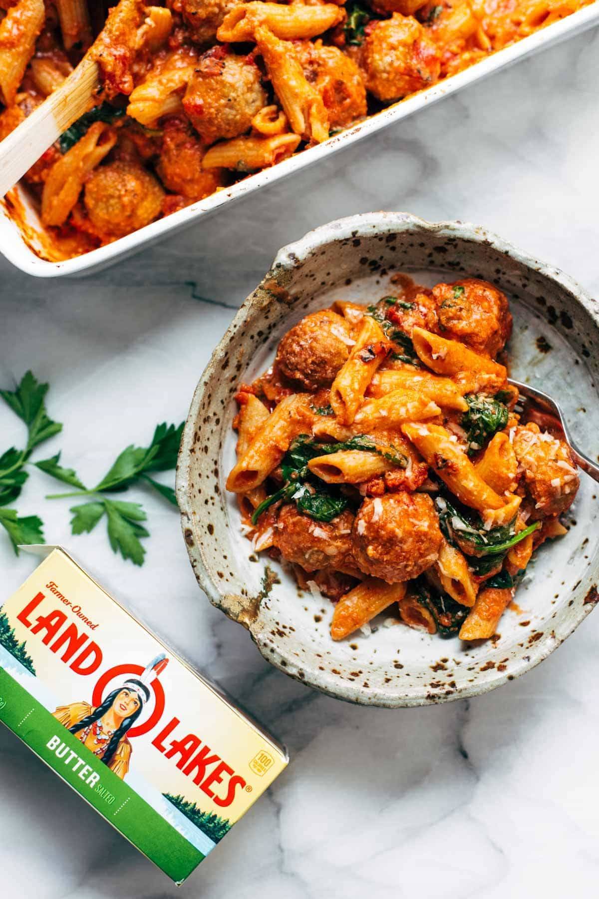 Baked penne with meatballs in a bowl.