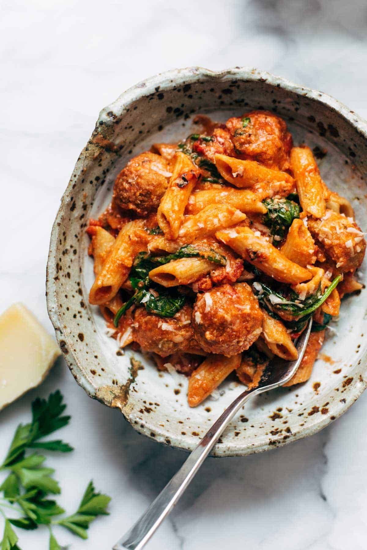 Baked penne with meatballs in a bowl.