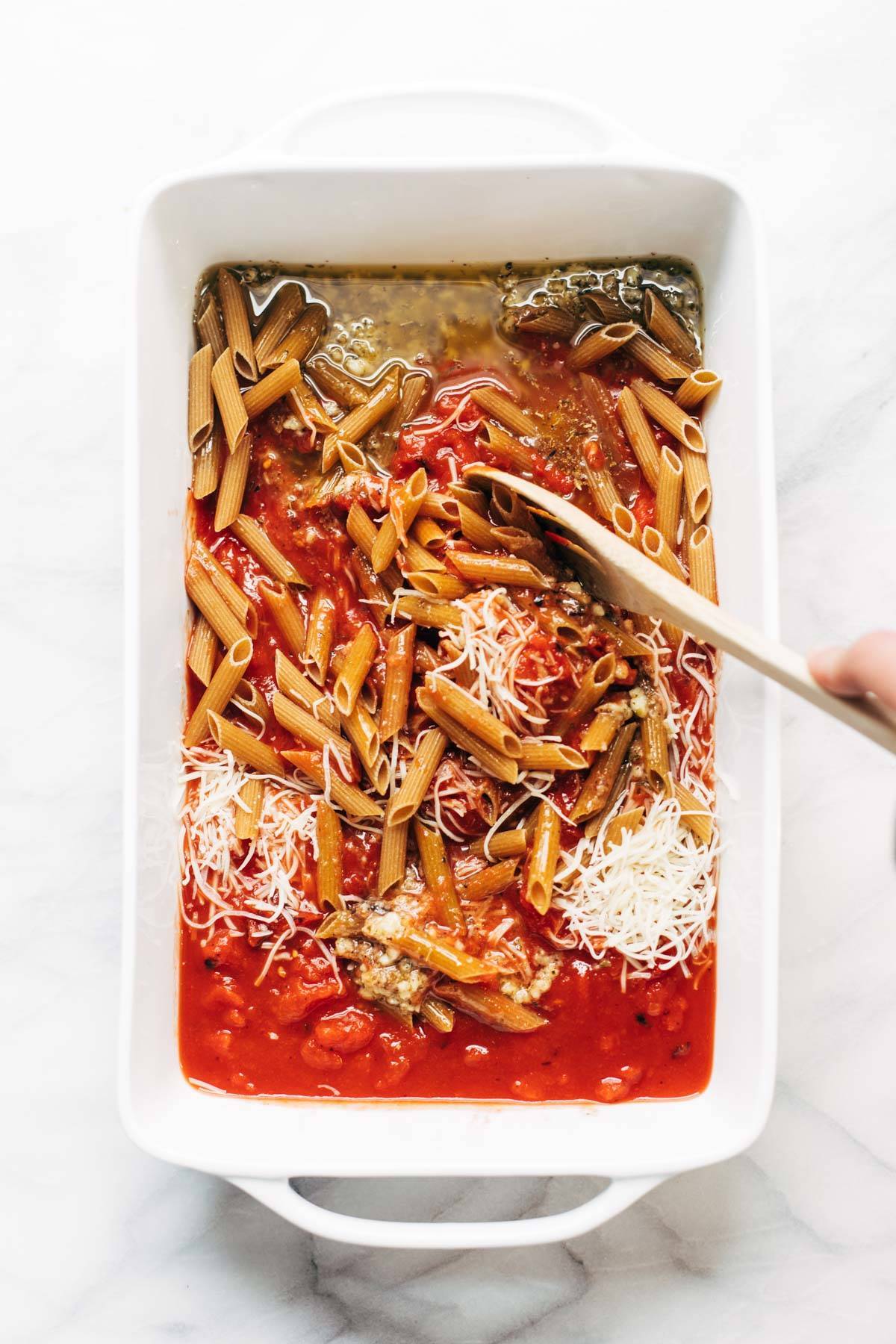 Ingredients for baked penne with meatballs in a dish.