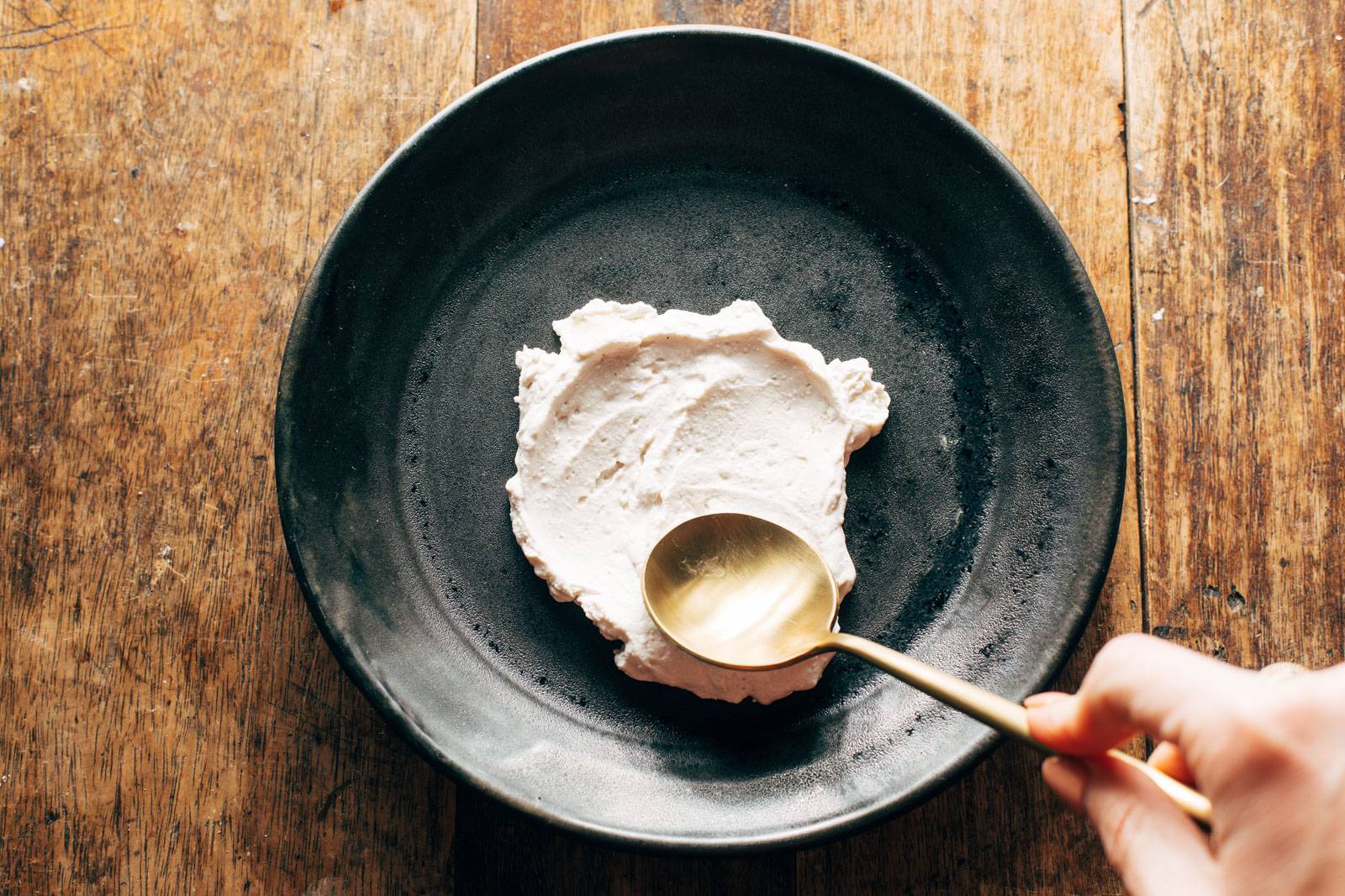 Spreading ricotta on a plate.