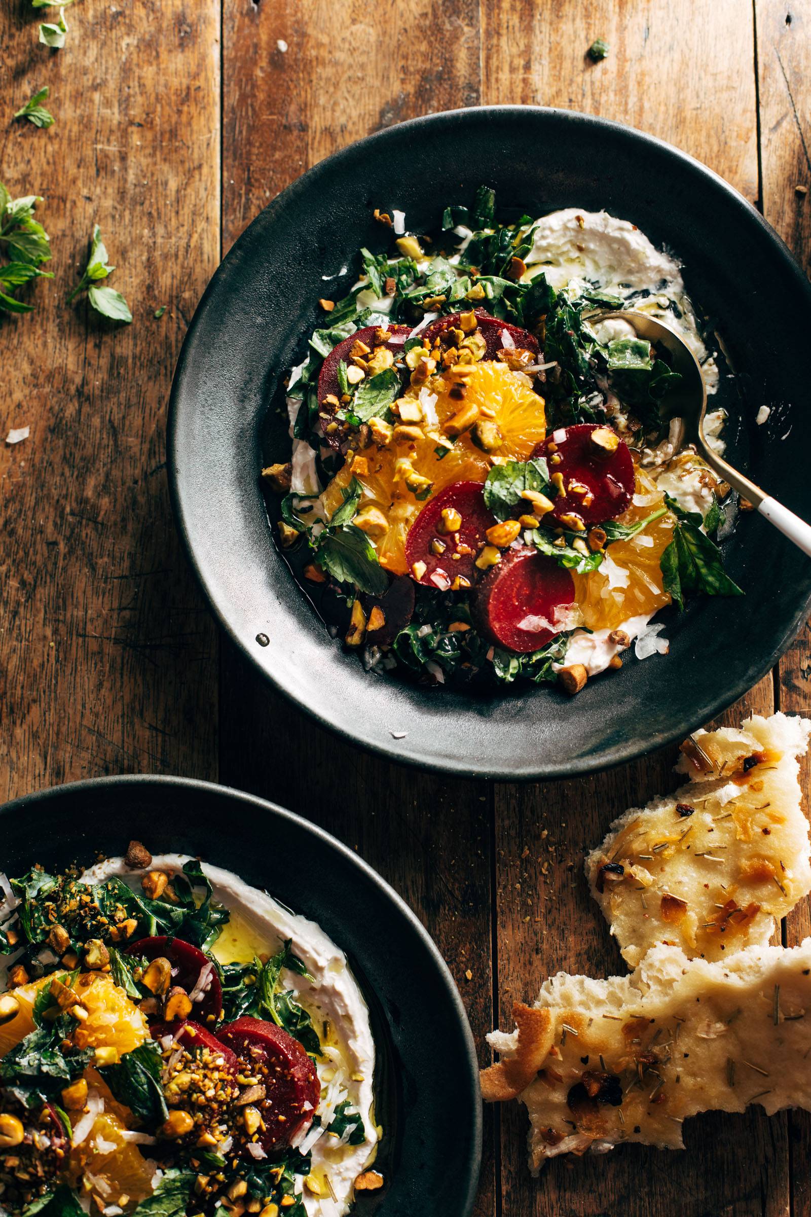 Beet salad in a bowl with whipped feta and garnishes