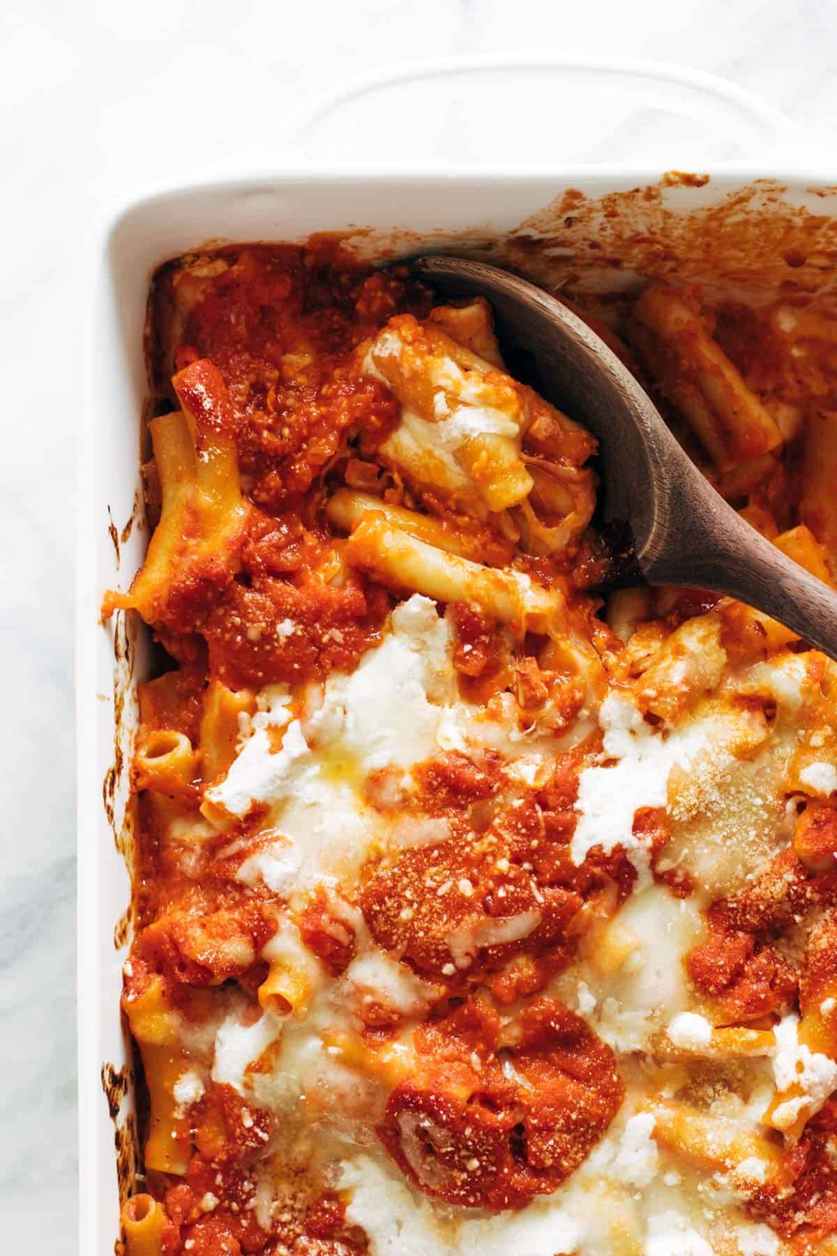 Baked ziti in pan with spoon.