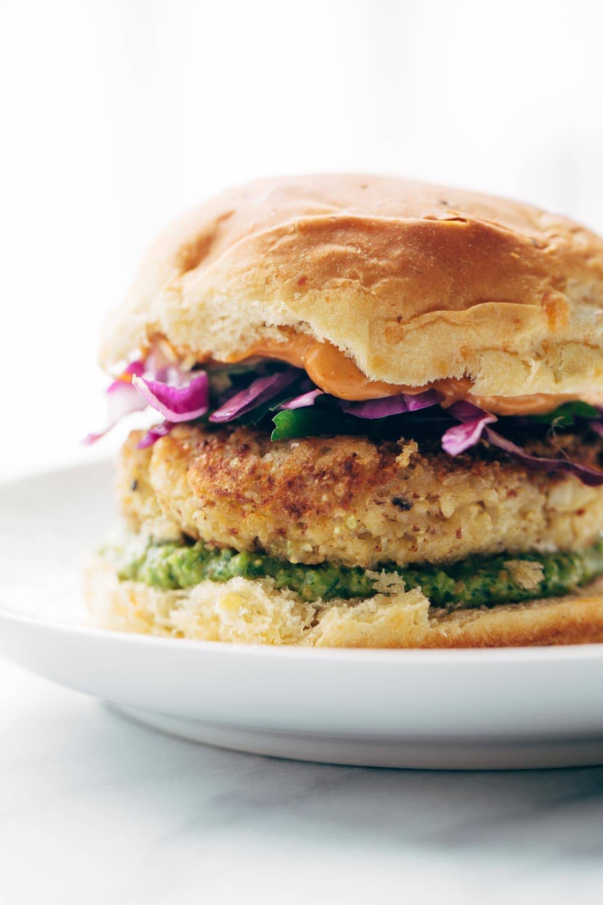 Recipe for Spicy Cauliflower Burgers with avocado sauce, cilantro lime slaw, and chipotle mayo! Meatless, filling, and delicious! | pinchofyum.com