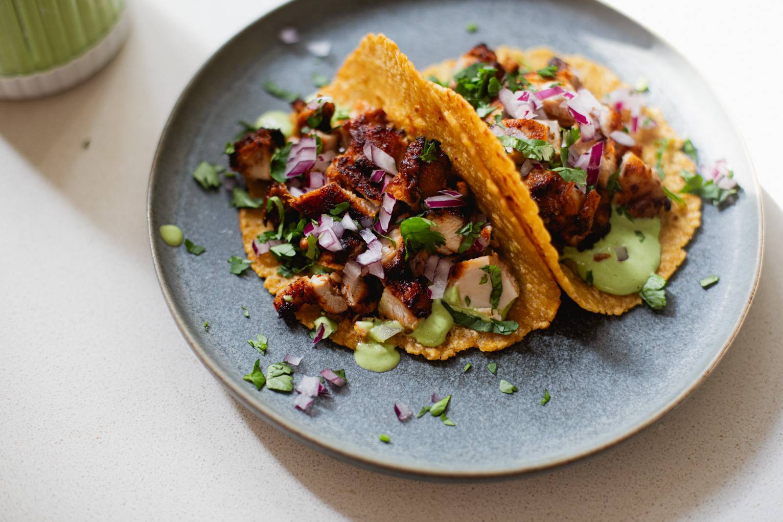 Two chicken tacos on a plate.