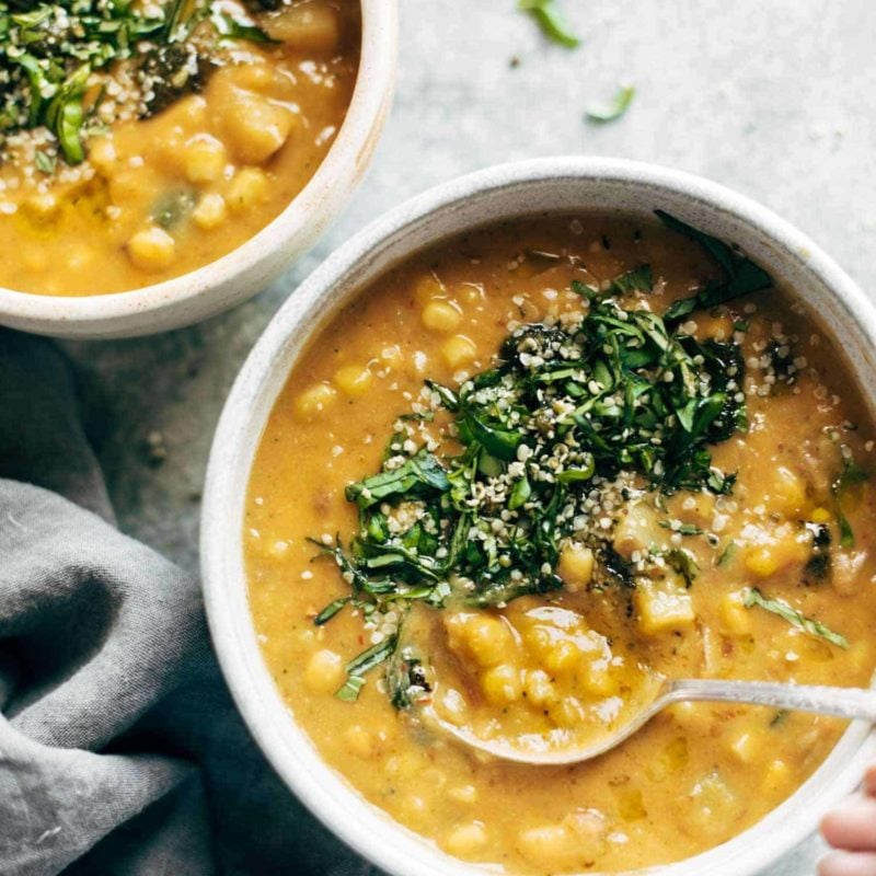 Corn chowder in a bowl with herbs on top.