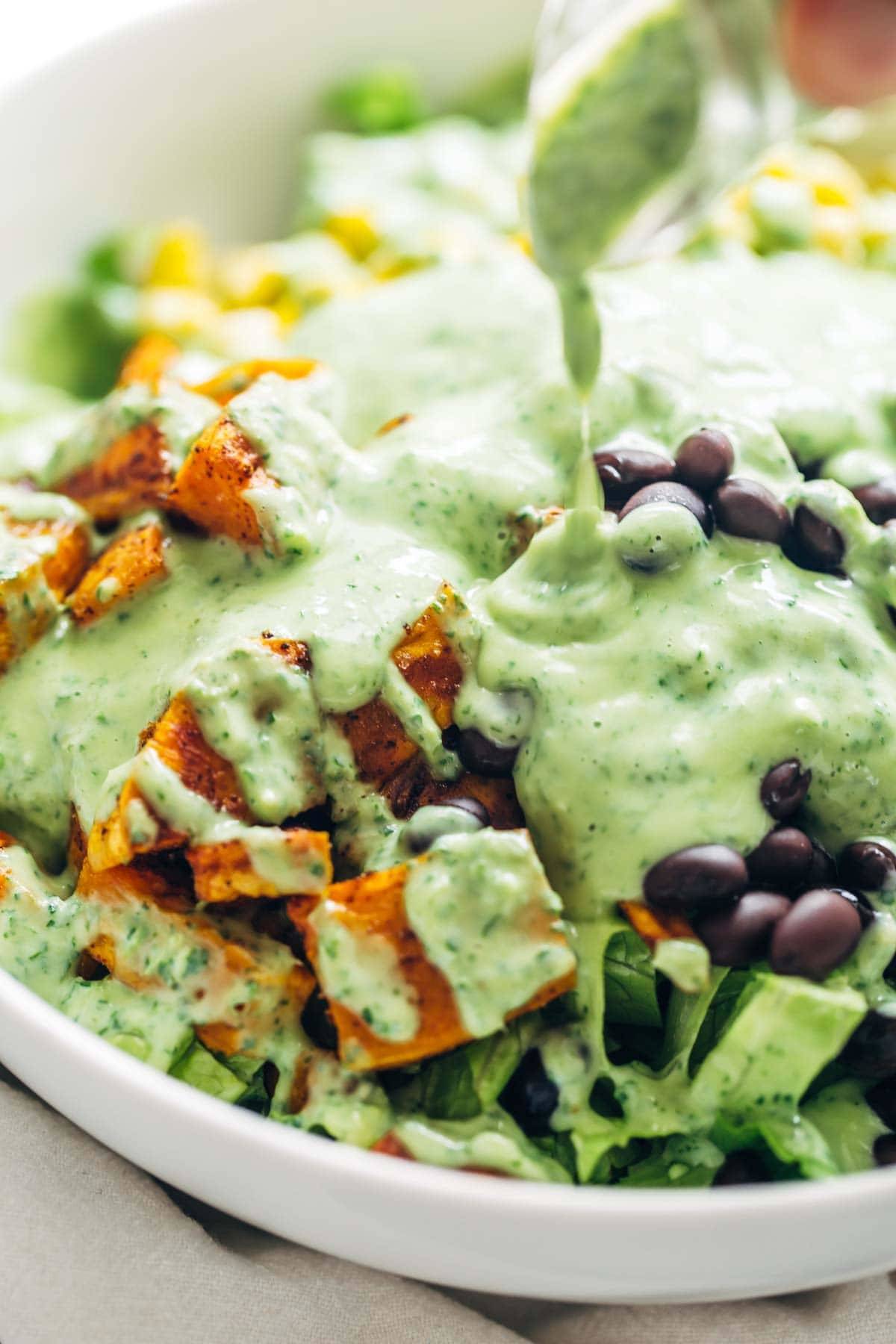 This healthy Spicy Southwestern Salad recipe has roasted sweet potatoes, black beans, corn, lettuce, and creamy avocado dressing! | pinchofyum.com