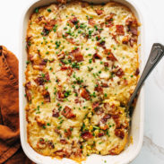 Corn casserole in a casserole dish with a serving spoon.