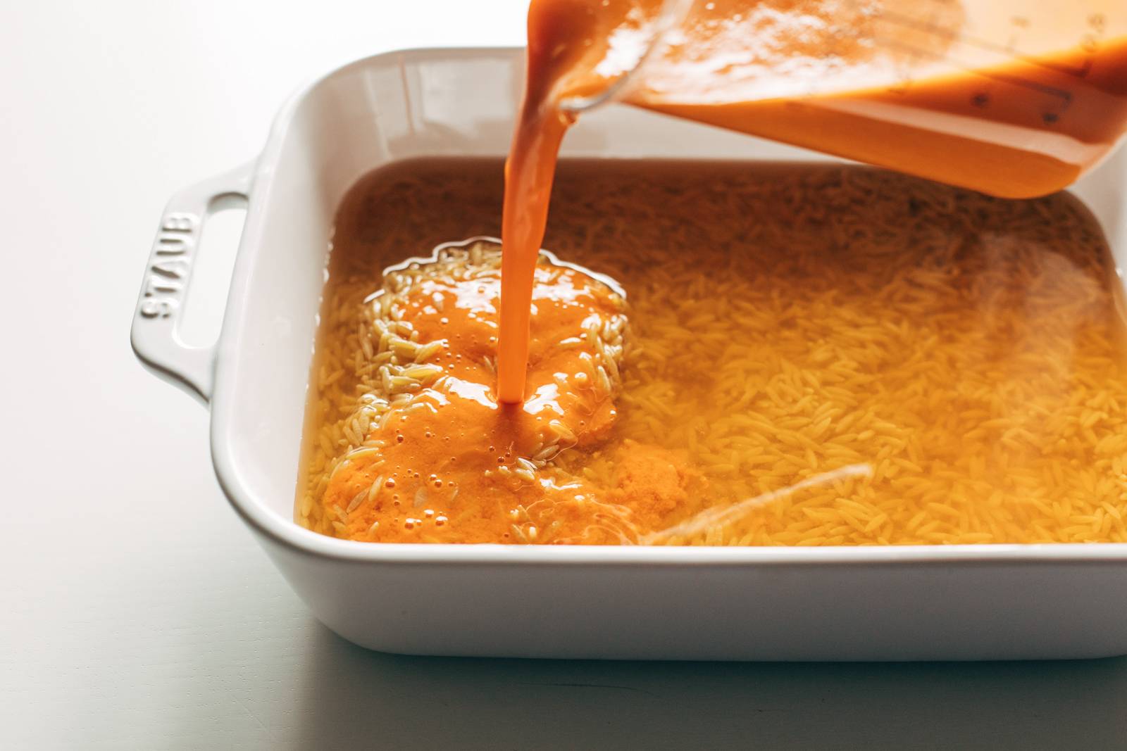 Tomato mixture gets poured into white pan.