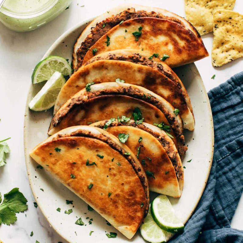 Crispy black bean tacos on a plate.