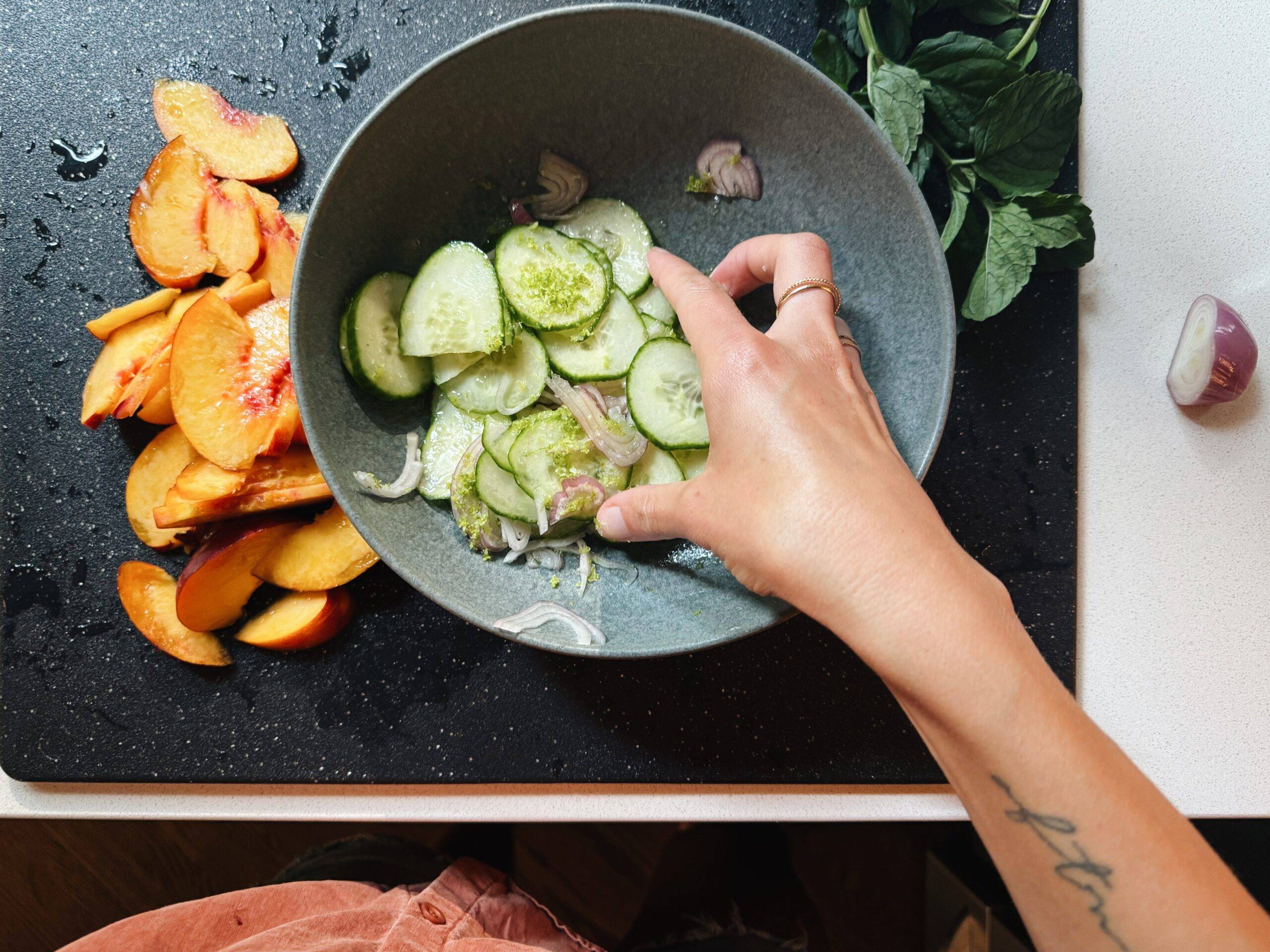 Mixing shallots, cucumber, and lime by hand.