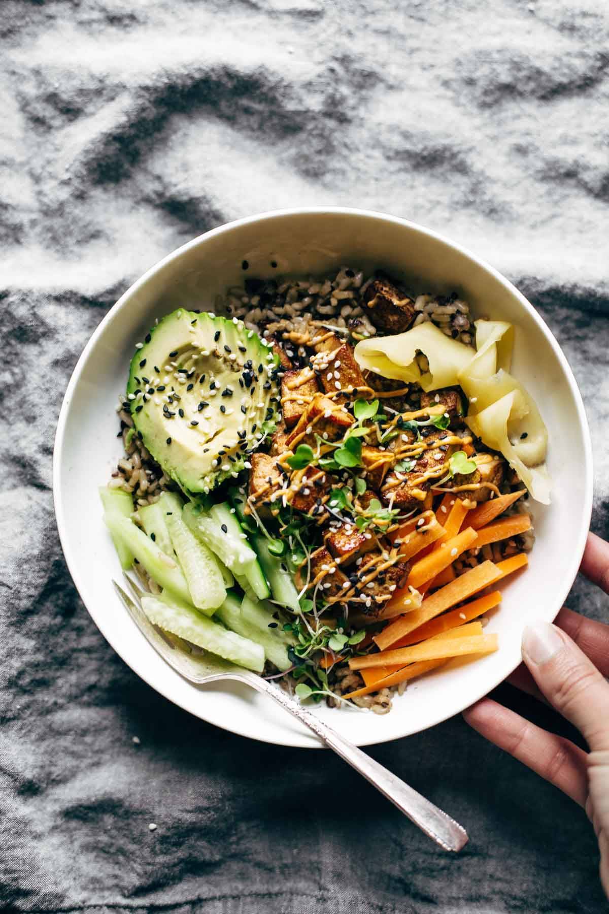 Sushi bowl on a napkin with a fork.