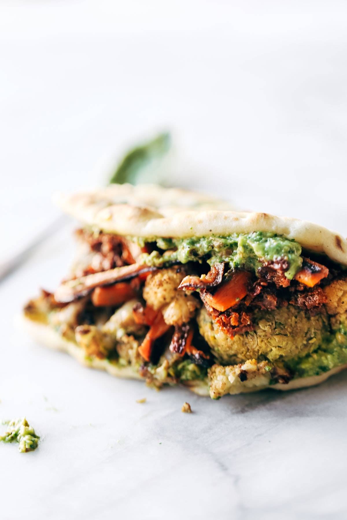 Naan-wich: 5 ingredient falafel, roasted veggies, and avocado sauce stuffed between pillowy garlic naan. Best sandwich recipe I've ever made. | pinchofyum.com