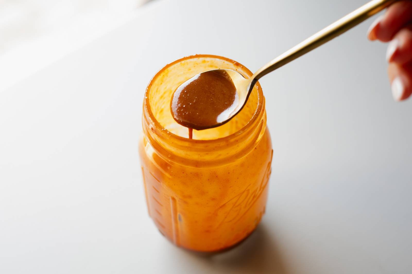 Gochujang sauce on a spoon from a jar.