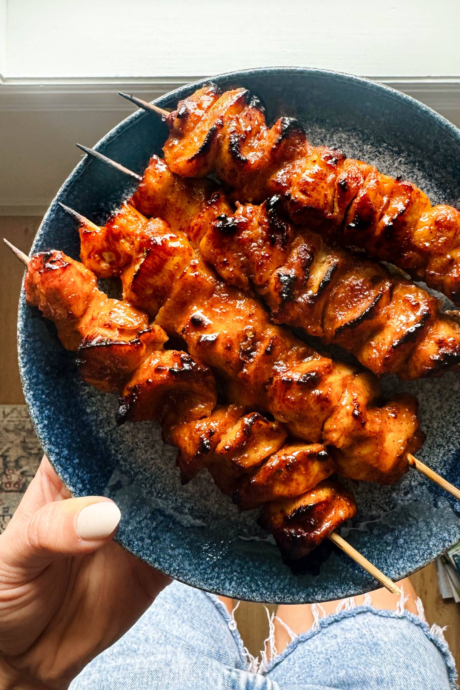 Honey chipotle chicken on skewers on a plate.