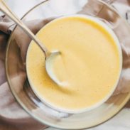 Honey mustard sauce in a bowl with a spoon.