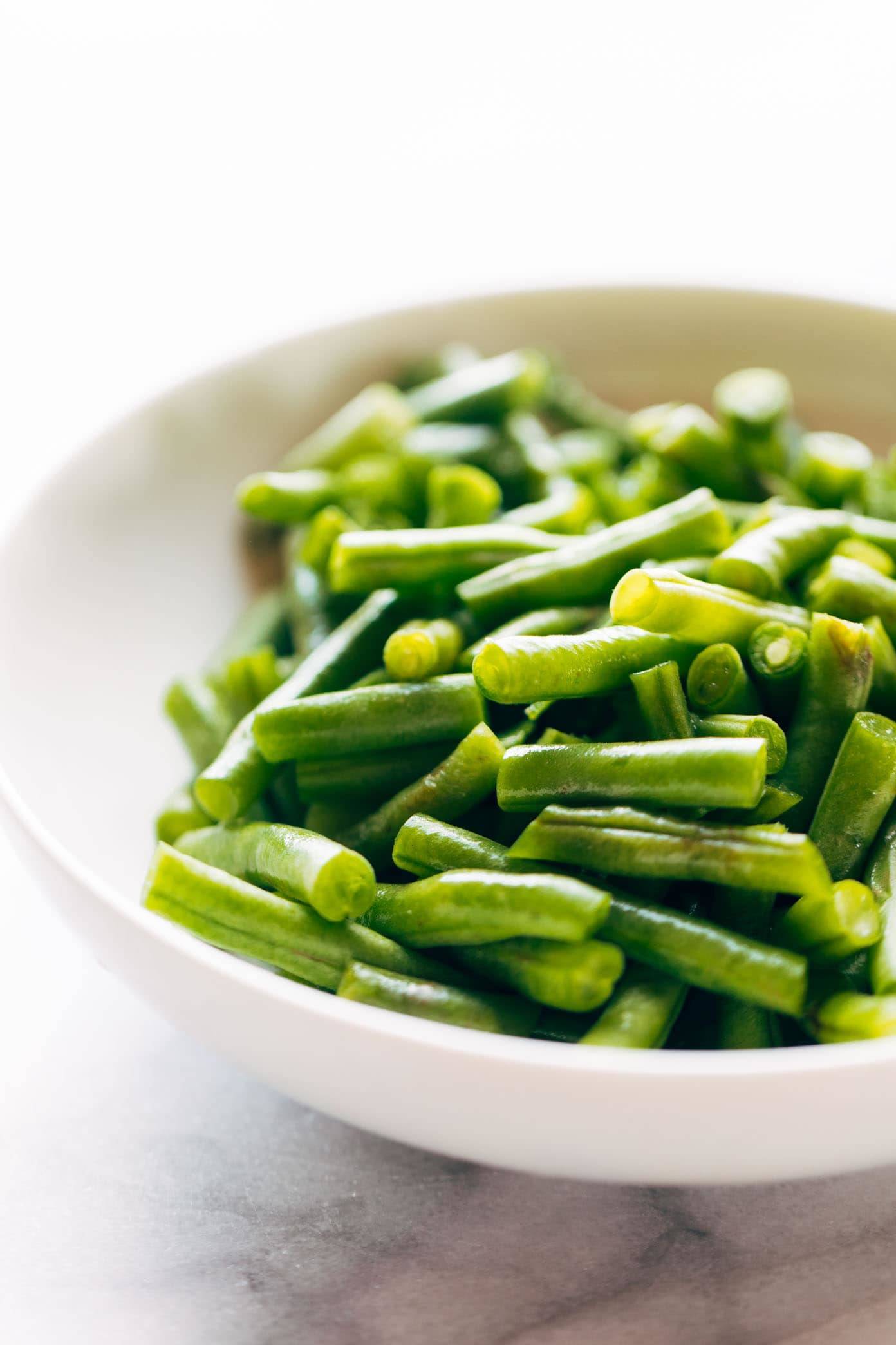 Green beans in a white bowl.