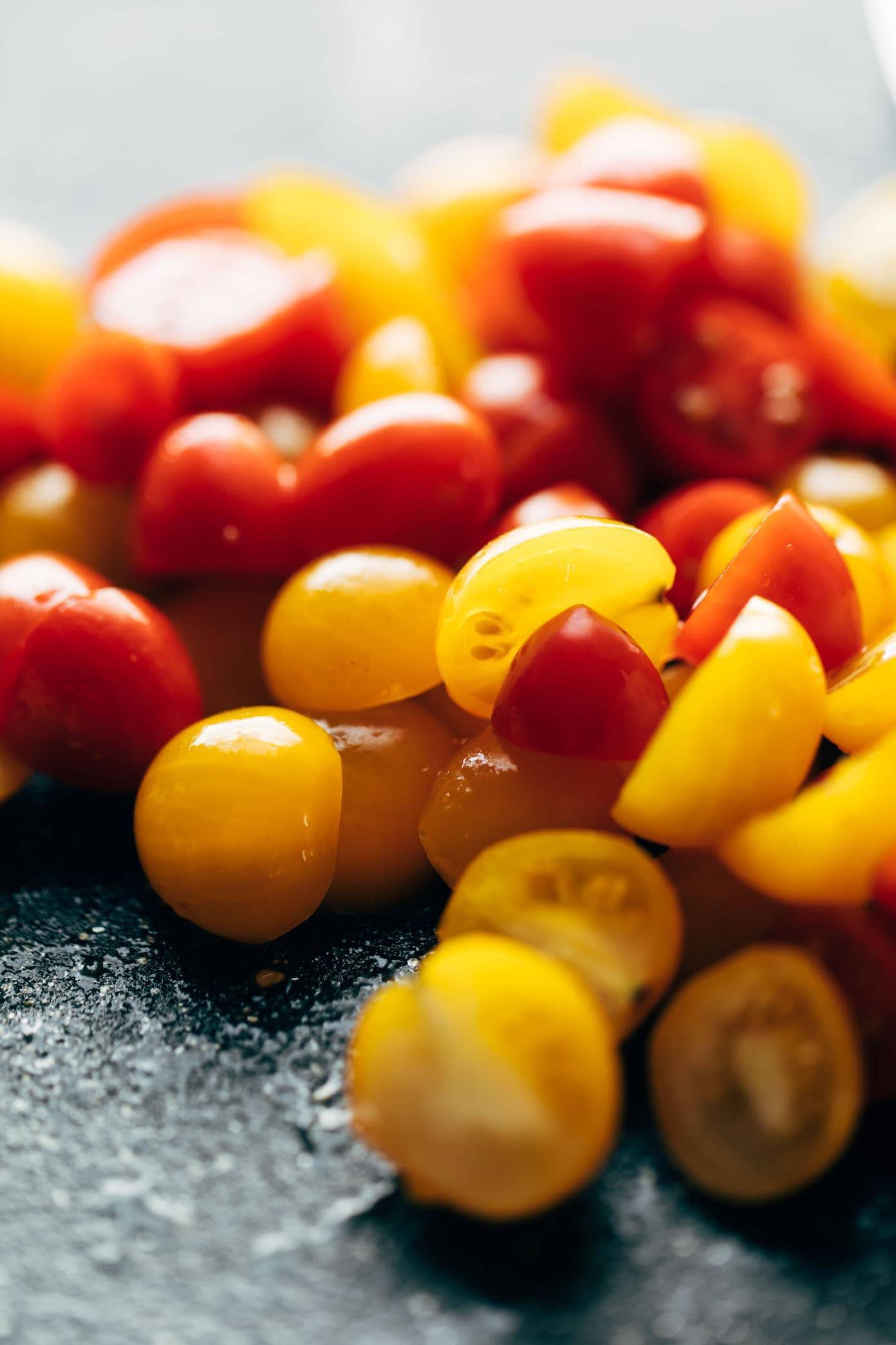 Tomatoes on a black cutting board.