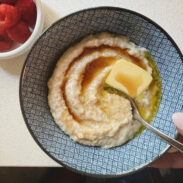 Oat bran in a bowl with maple syrup and butter.