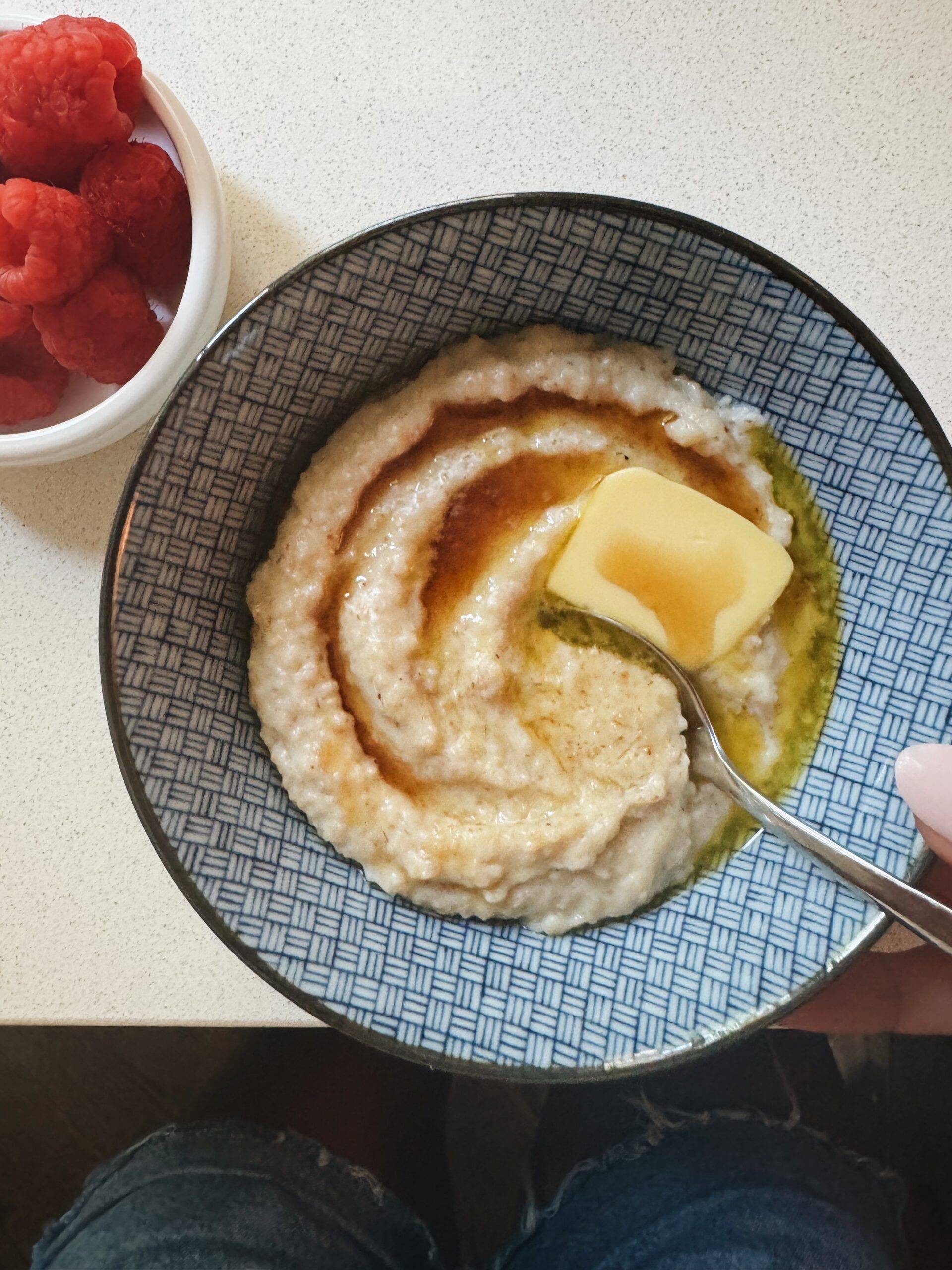 Oat bran in a bowl with maple syrup and butter.