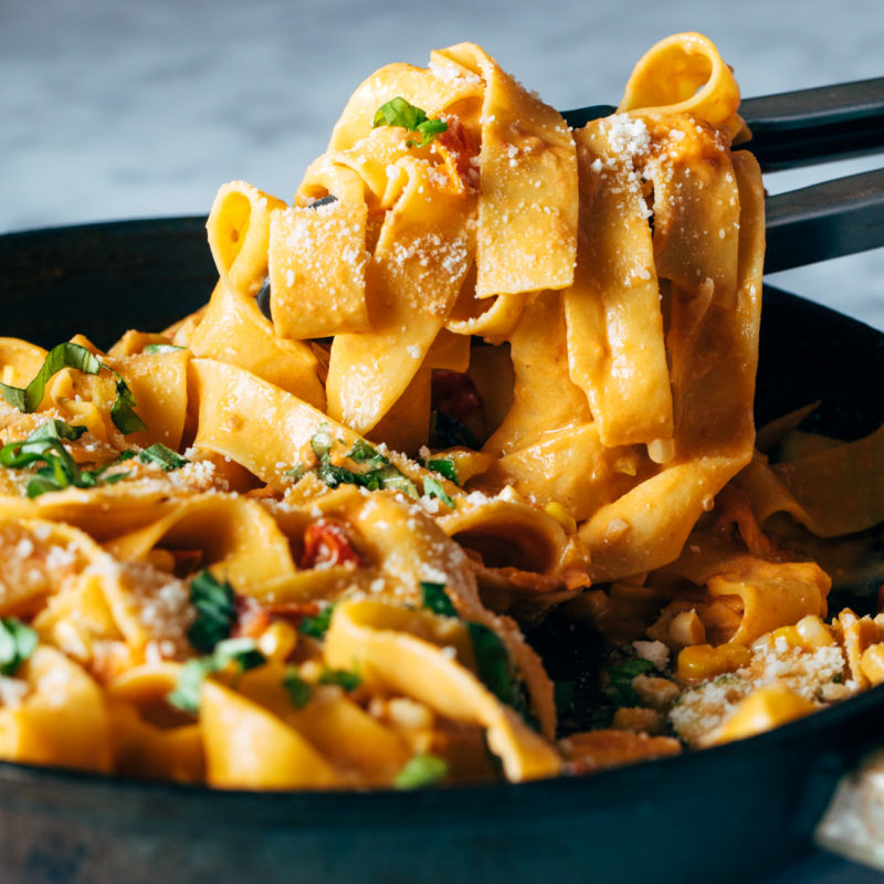 A picture of Burst Tomato Pappardelle with Zucchini, Sweet Corn, and Pan-Fried Chicken