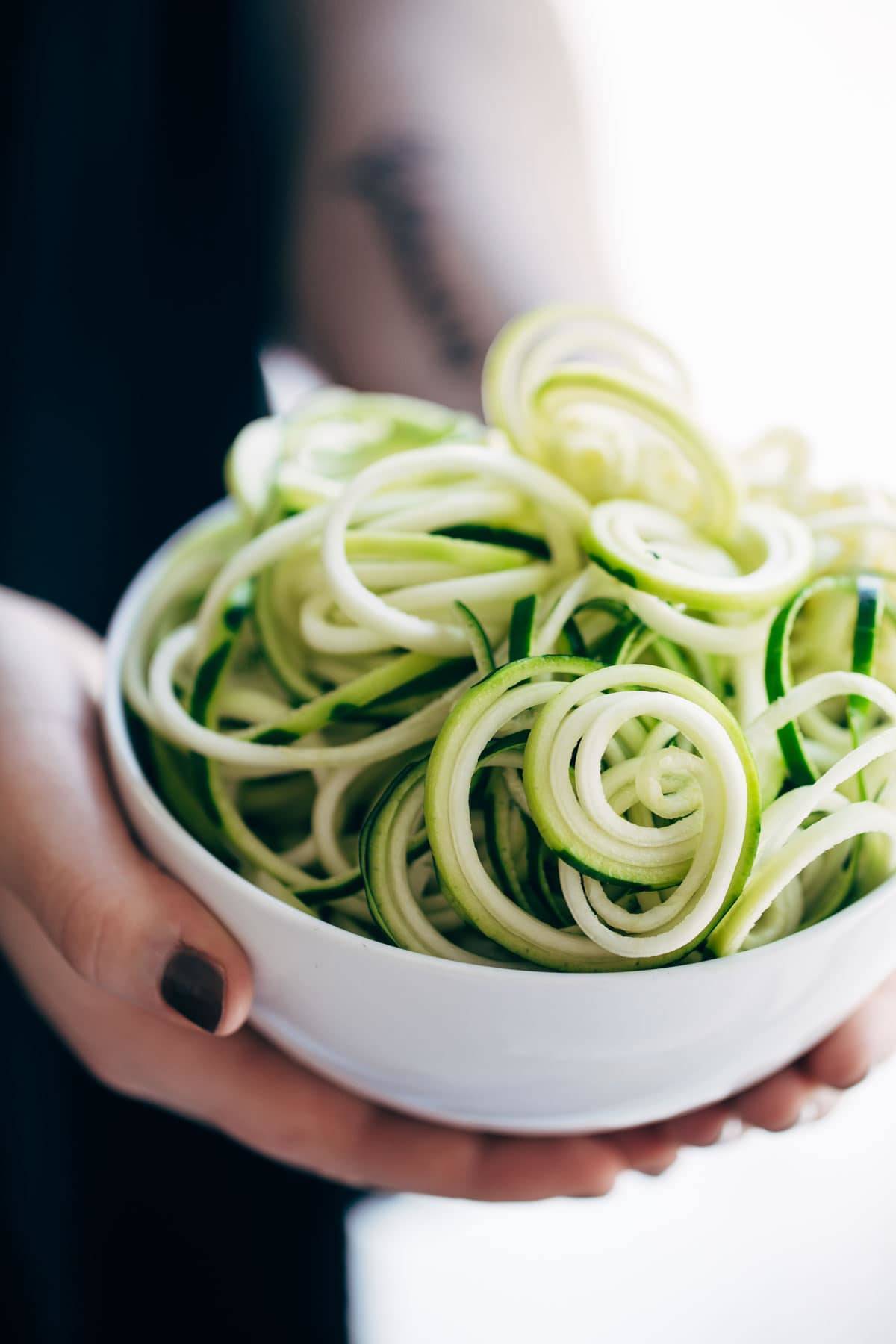 Green zoodles in a bowl.