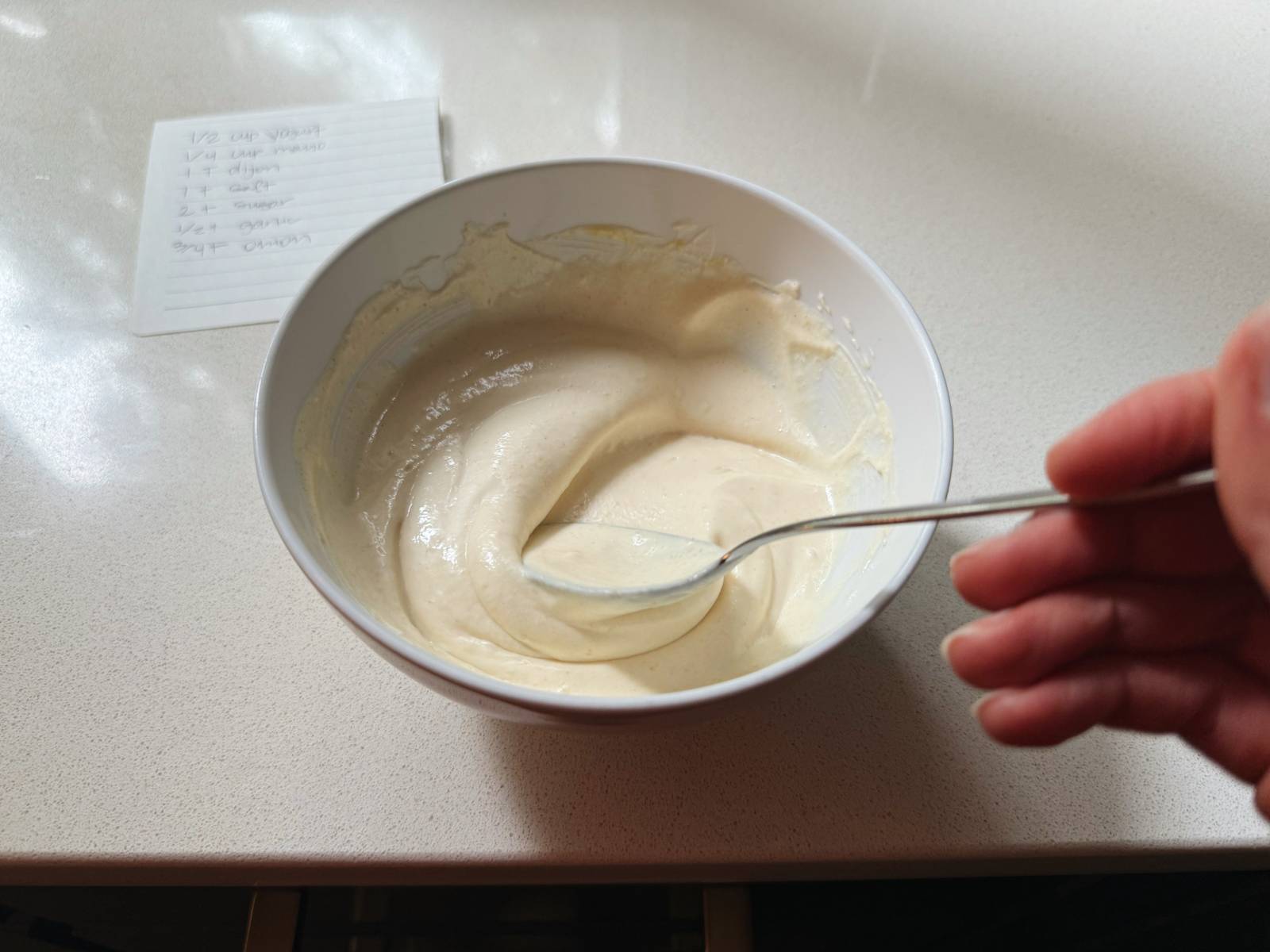 Mixing dressing for chicken salad in a bowl.