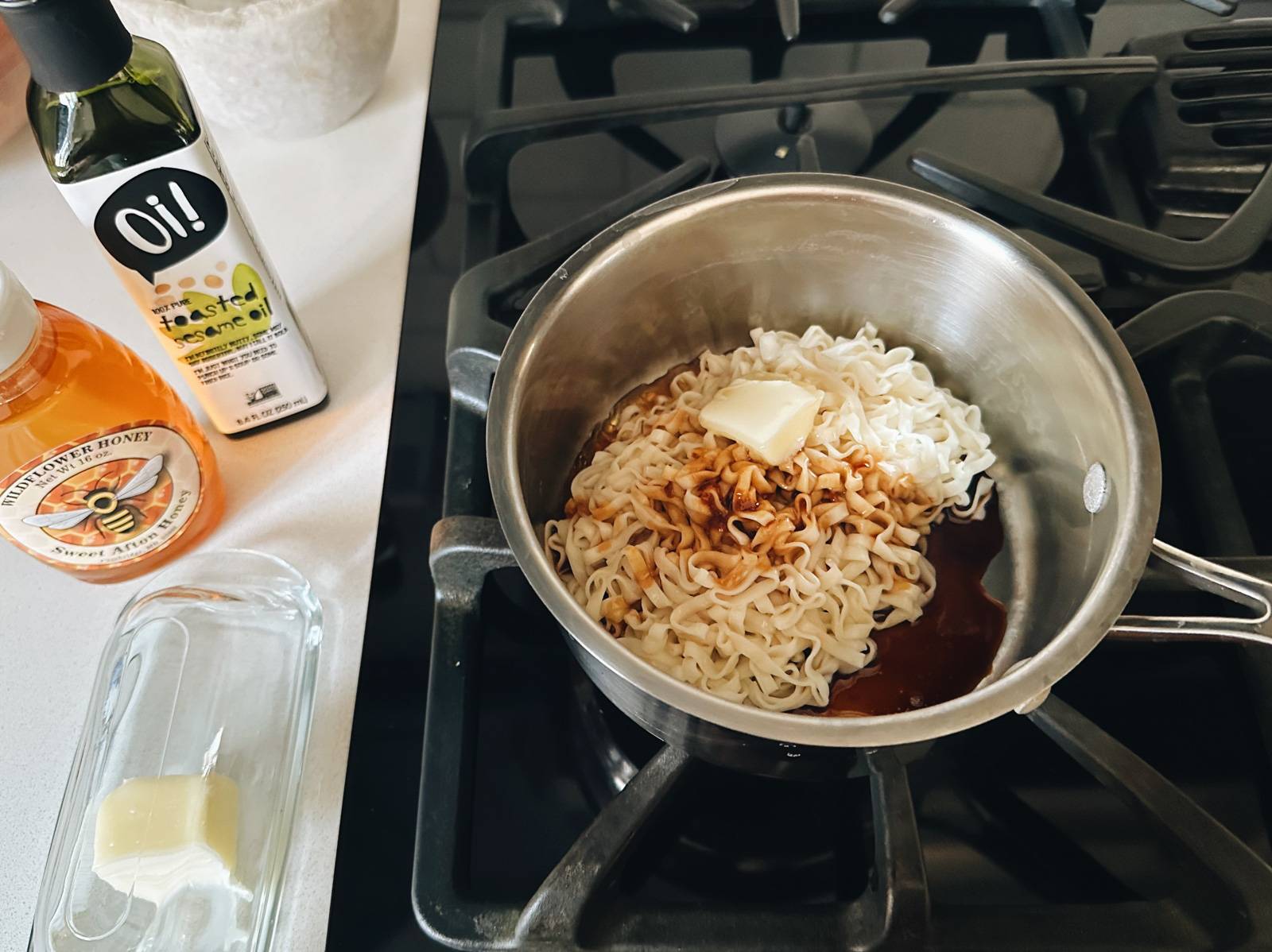 Noodles, sauce, and butter in a pot.