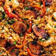 Cauliflower rice and meats arranged together on a sheet pan.