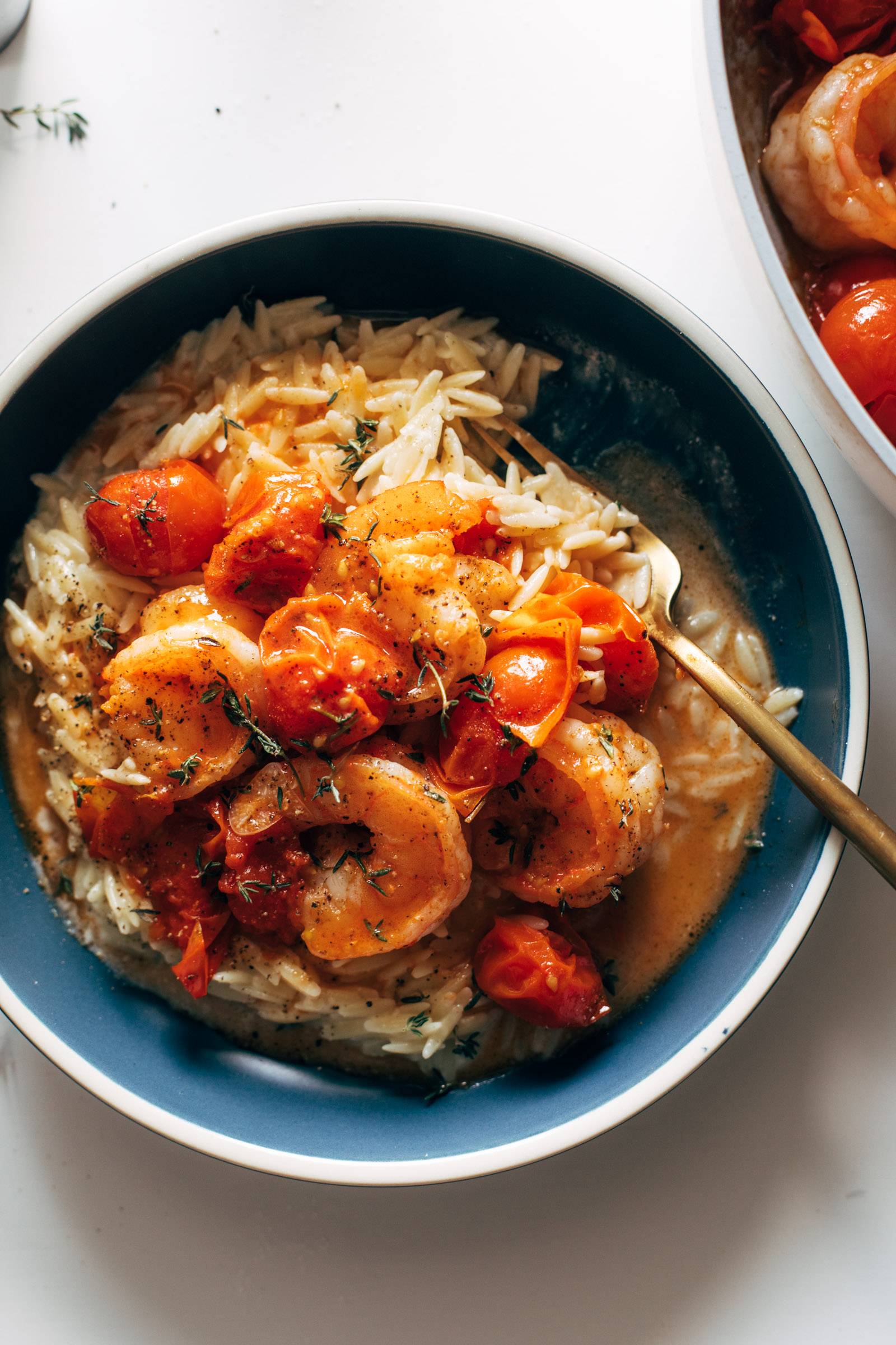 Orzo, shrimp, and tomatoes in a bowl.