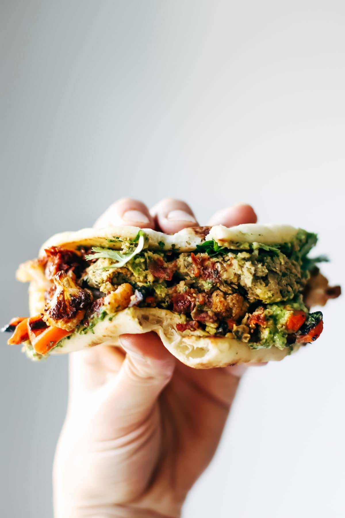 Naan-wich: 5 ingredient falafel, roasted veggies, and avocado sauce stuffed between pillowy garlic naan. Best sandwich recipe I've ever made. | pinchofyum.com