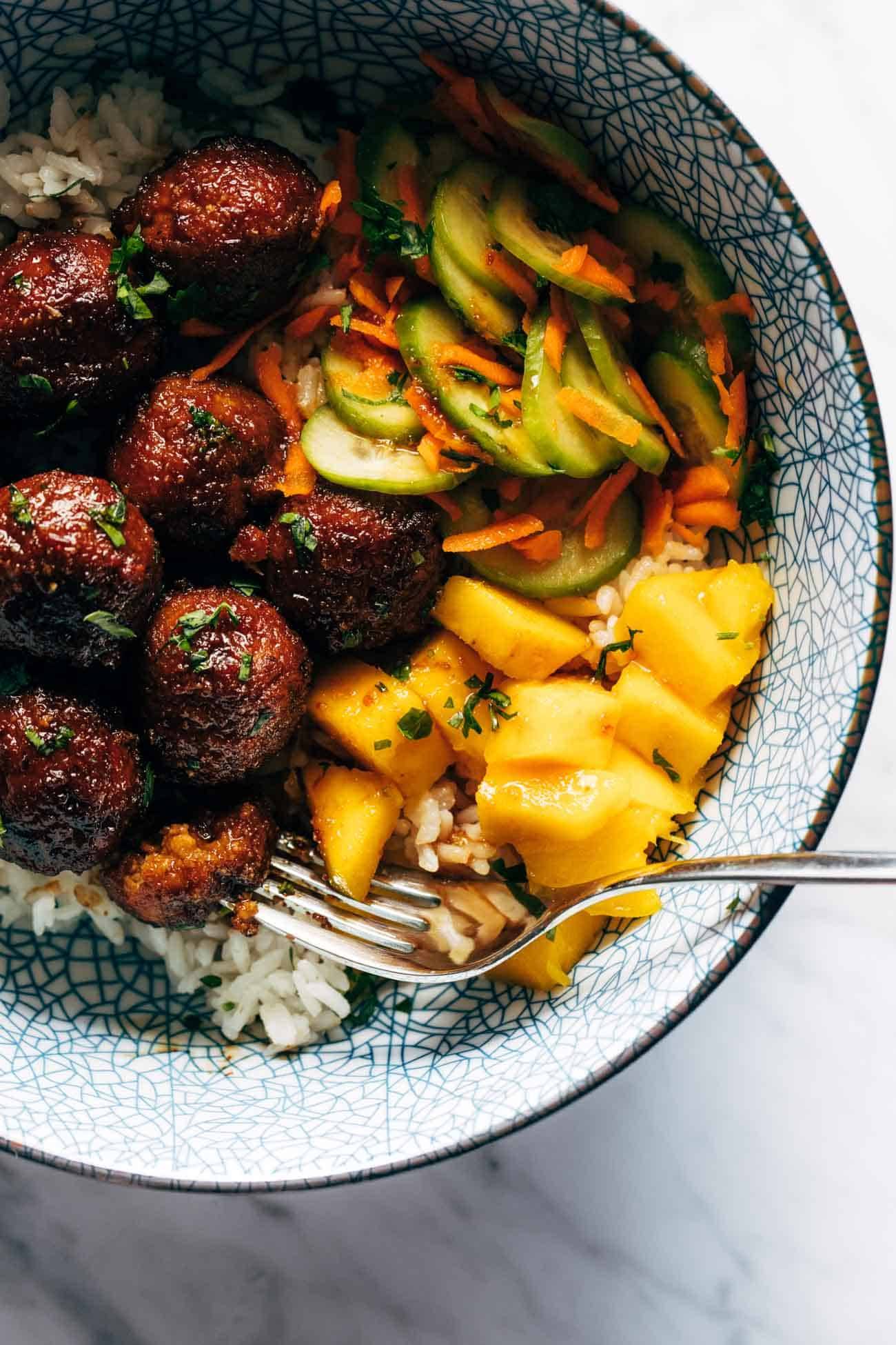 Sticky ginger rice bowls with mango and pickled veg with a fork in a bowl