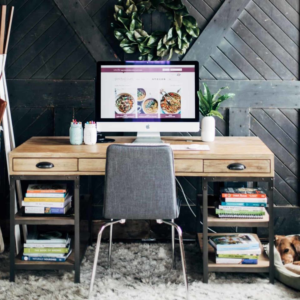 Desk with a chair in front of a grey wooden door.