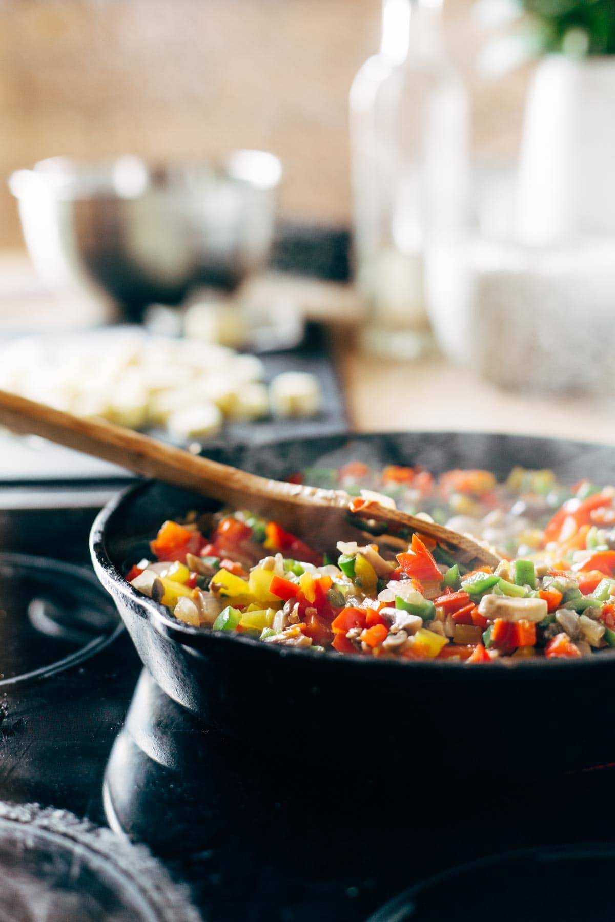 sweet potato tater tot hotdish in a skillet with a wooden spoon