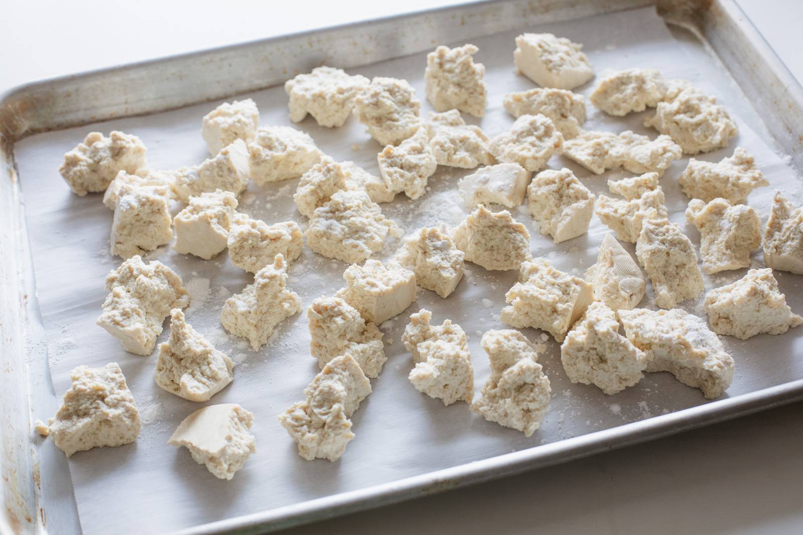 Torn tofu on a sheet pan.